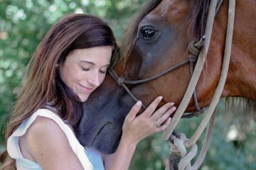 a woman petting a horse